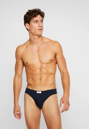 Marineblaue Herrenbikini-Briefs aus weichem Material, mit einem engen Sitz und einem kleinen Logo-Tag am Bund.