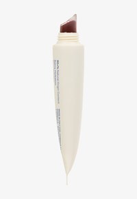 Tubo blanco, alargado con un diseño acampanado y abertura en ángulo. Contiene un producto de color marrón oscuro. Presenta texto en azul que detalla la composición natural.