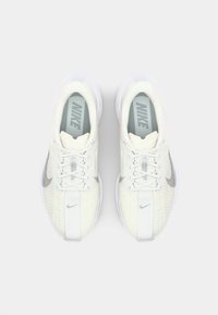 Nike sneakers i hvid mesh med sølvaccenter, der har en rund tå, flade snørebånd og en polstret sål. Logo på siden og på tungen.
