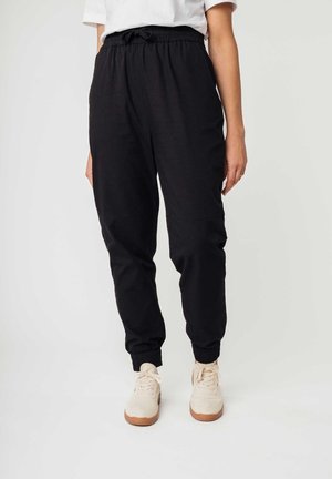 Zwarte joggingsbroek van zachte stof, met een elastische tailleband met een trekkoord, ribgebreide boorden en standaard zijzakken.