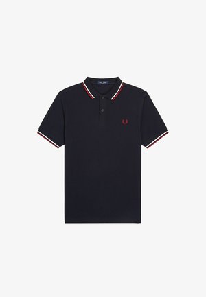 Polo azul marino de manga corta, con cuello abotonado y ribete a rayas rojas y blancas en el cuello y los puños, con un pequeño logo de laurel rojo.