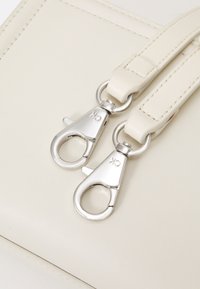 Calvin Klein MINIMAL HARDWARE CROSSBODY - Soma ar siksnu pāri ķermenim - ecru