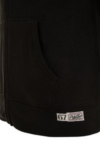 Černá kapuce s kapsou a bílou obdélníkovou etiketou s nápisem "67" a značkou "Polo RL" blízko spodního lemu.