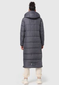 Long gray puffer coat with a high collar, horizontal stitching, and a logo tag at the hem. Features a loose fit and a smooth texture.