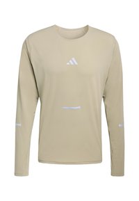 Béžové športové tričko s dlhým rukávom a okrúhlym výstrihom, s bielym logom Adidas uprostred na hrudníku a malými bielymi reflexnými pruhmi na rukávoch a prednej časti.
