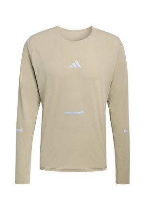 Beżowa sportowa koszulka z długim rękawem i okrągłym dekoltem oraz białym logo Adidas na środku klatki piersiowej, z małymi białymi odblaskowymi paskami na rękawach i z przodu.