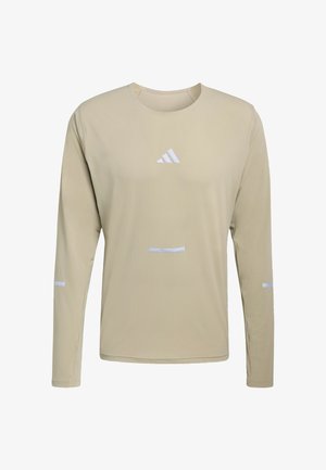 Beige long-sleeve athletic shirt with crew neck and white Adidas logo centered on chest, plus small white reflective stripes on sleeves and front.