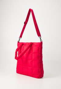 Sac fourre-tout matelassé en rose vif avec une texture rembourrée. Doté d'une bandoulière ajustable et d'un motif matelassé. Équipé de poignées doubles.