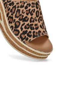 Sandal de cuña con estampado de leopardo y punta abierta, con una suela de corcho y un acabado mate en la parte superior en tono marrón. La superficie texturizada añade detalle.