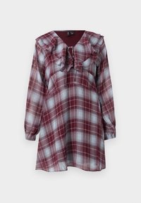 Φόρεμα με μακρύ μανίκι σε κόκκινο και μπλε καρό, με ραμμένο V-ντεκολτέ και άνετη εφαρμογή. Κατασκευασμένο από ελαφρύ υλικό με λεία υφή.