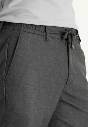 Graue gewebte Hose mit elastischem Bund und Kordelzug. Verfügt über seitliche Taschen und hat ein maßgeschneidertes Erscheinungsbild mit strukturierter Oberfläche.
