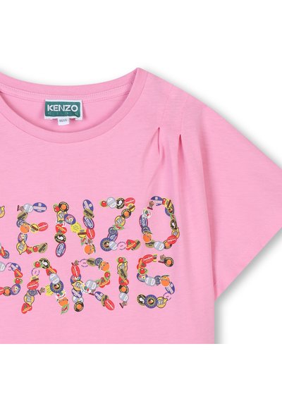 T-shirt en coton rose avec un col rond, des manches courtes et des détails plissés, présentant "KENZO PARIS" dans des motifs de patch colorés et graphiques.