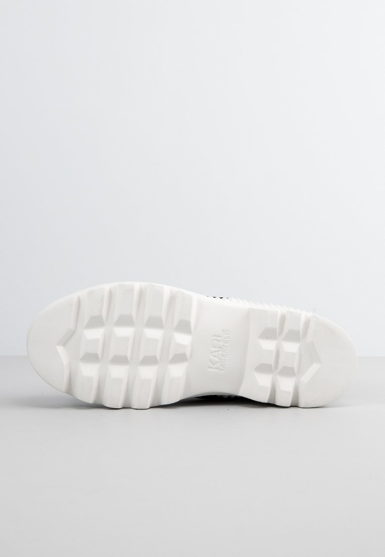 Semelle de chaussure en caoutchouc blanc avec des motifs géométriques profonds et le logo "KARL LAGERFELD" en relief au centre.