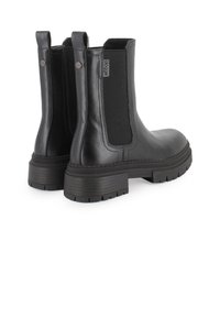 Botas Chelsea de cuero negro con paneles elásticos en los laterales, suelas de goma y un acabado texturizado. Cuentan con una lengüeta para facilitar el calzado.