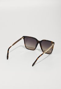 Square sunglasses with a tortoiseshell pattern, gradient lenses, and gold metal accents on the arms. Features a textured finish.