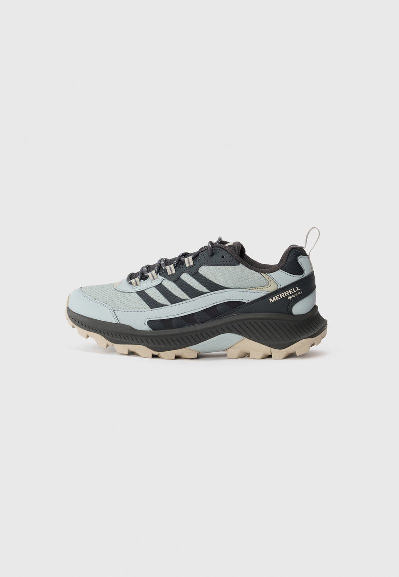 Buty trailowe Merrell w jasnoniebieskim i czarnym kolorze, z siateczkową cholewką, gumową podeszwą, wyściełanym kołnierzem i trwałymi sznurowadłami, zaprojektowane z myślą o stabilności.