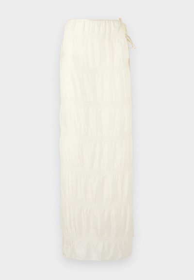 Μακριά λευκή φούστα με σοβάδες, με τμήματα με σούρες και κορδόνι στη μέση σε ανοιχτό φόντο.