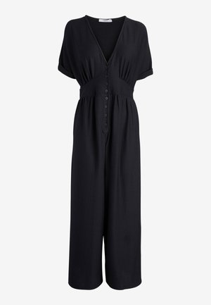 Combinaison noire à manches courtes avec un profond décolleté en V, fermeture boutonnée devant, taille froncée et pantalon large raccourci.