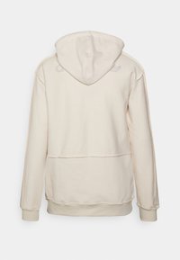 Krémová mikina s kapucňou vyrobená z mäkkej látky, s klokánkovou kapsou, rebrovanými manžetami a kapucňou. Jemné logo v svetlo šedej farbe na pleciach.