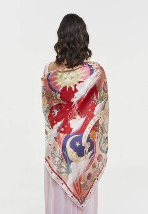 Naisella, jolla on aaltoilevat tummat hiukset, on värikäs silkkihuivi, jossa on aurinko, kuu, pilviä, kukkia ja lintuja, verhottuna vaalean mekon päälle.