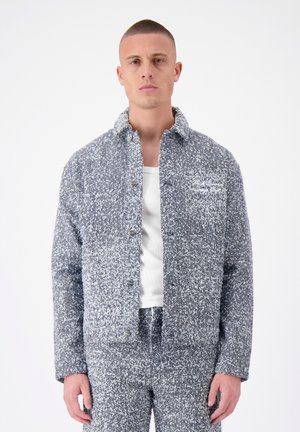 Textured gray and white jacket with a button-up front, spread collar, and two side pockets, styled with a matching bottom piece.