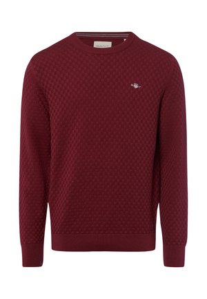 Bordeauxfarbener Pullover mit strukturiertem Wabenmuster, runder Ausschnitt und gerippten Bündchen und Saum. Kleines Logo auf der Brust.