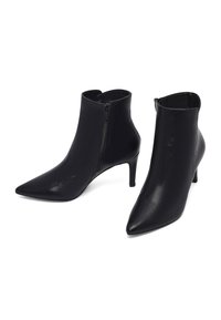 Zwarte leren enkellaarzen met spitse neuzen, ritssluitingen aan de zijkant en slanke midhakken op een witte achtergrond.