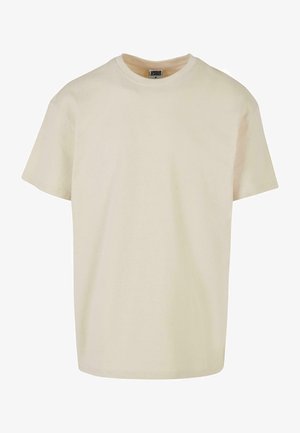 Camiseta de algodón de manga corta y cuello redondo en color beige claro. Corte clásico con dobladillo recto y sin estampados ni adornos.