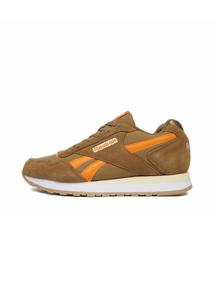 Zapatilla Reebok marrón y naranja con paneles de ante y cuero, suela blanca y logo de Reebok en el lateral y el talón.