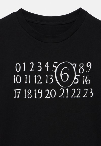 Maglietta nera in cotone con numeri bianchi stampati disposti a griglia, con il numero 6 evidenziato in una forma ovale.