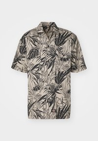 Koszula z krótkim rękawem wykonana z lekkiej tkaniny, z beżowym tłem i czarnym wzorem tropikalnych liści oraz dwiema kieszeniami na piersi.