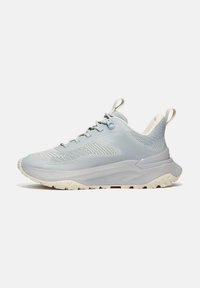 Hellblaue Sportschuhe mit einem Obermaterial aus Mesh, strukturierten Details, einer Zuglasche und einer dicke, gepolsterten Sohle mit einem robusten Profil.