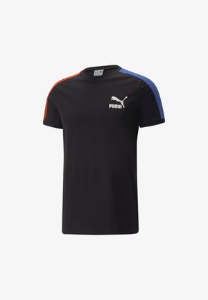 Camiseta negra con acentos en rojo y azul en los hombros, que presenta un logo blanco de Puma en el lado izquierdo del pecho. Fabricada con un tejido suave.