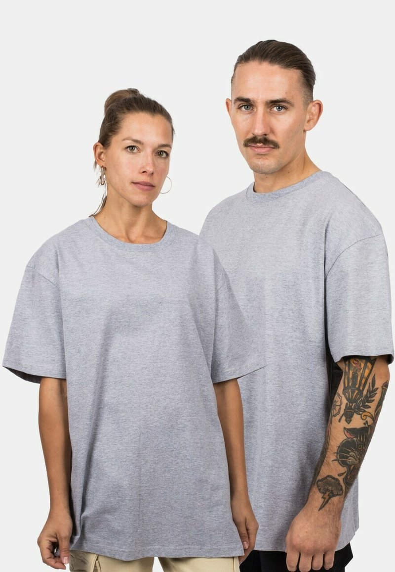Grijze, overmatige t-shirts van een katoenmix. Beschikt over korte mouwen, ronde hals en een ontspannen pasvorm. Effen zonder patronen of accenten.