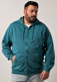 Tyrkysová mikina s kapucí na zip, vyrobená z měkkého materiálu, s přední kapsou, žebrovanými manžetami a kapucí na šňůrku.