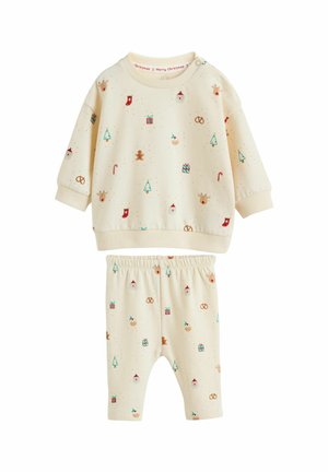Completo per bambini di colore crema composto da un top a maniche lunghe e pantaloni con vita elastica, decorato con motivi a tema natalizio.