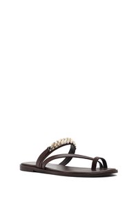 Sandalo basso marrone scuro con due sottili cinturini, uno dei quali presenta un dettaglio a catena dorata intrecciata, e un anello per l'alluce su sfondo bianco.