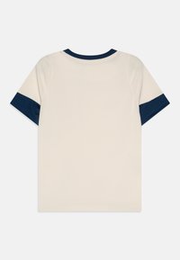 T-shirt crema a maniche corte con colletto e dettagli delle maniche blu navy, caratterizzato da una superficie liscia e una vestibilità classica.