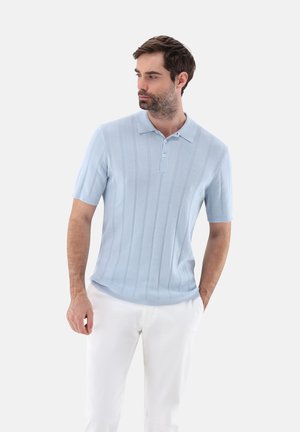 Helles blaues Poloshirt mit kurzen Ärmeln, das über eine gerippte Struktur und eine Dreiknopfleiste verfügt, kombiniert mit weißen Hosen.