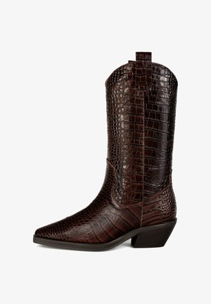 Rjavi usnjeni kavbojksi čevelj s krokodiljim vzorcem, s koničastim nosom, srednjo peto in zanko na zadnji strani. Ima strukturo površinske teksture.