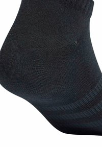 Svart ankelsocka gjord av mjukt, texturerat material med ett ribbat mönster och sömlös tå för komfort och hållbarhet.