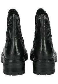 Botas de tobillo de cuero negro con punteras redondeadas, acabado texturizado, acentos de ojales en la parte trasera y suelas negras gruesas. Presenta un detalle del logo en el lateral.