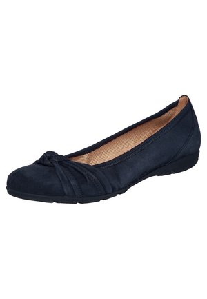 Chaussure plate en daim noir avec bout arrondi, détail nœud décoratif et doublure intérieure beige.