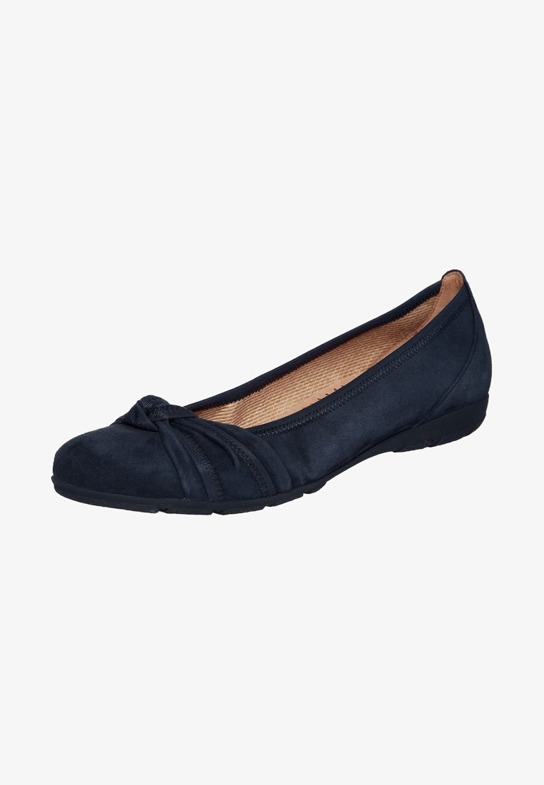 Chaussure plate en daim noir avec bout arrondi, détail nœud décoratif et doublure intérieure beige.