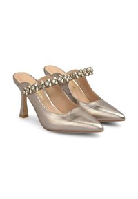 Mule con tacco in oro metallico con punte affusolate e una fascia decorativa di strass. Texture in pelle liscia e design con tacco medio sottile.