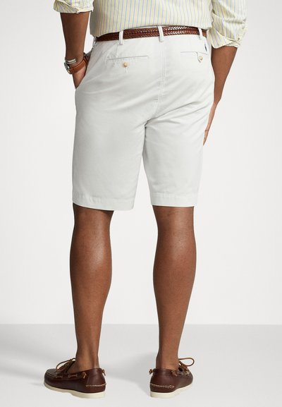 Ανοιχτό γκρι βαμβακερές σορτς με ίσια κοπή, πίσω τσέπες και πλεκτή καφέ δερμάτινη ζώνη, συνδυασμένα με καφέ σκαφάκια.