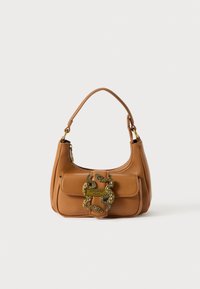 Tanfarbene Lederhandtasche mit einem geschwungenen Griff, goldfarbener, schlangenförmiger Hardware und einem Reißverschluss oben. Sie zeichnet sich durch eine glatte Textur und ein kompaktes Design aus.