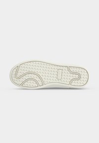 Semelle de chaussure en caoutchouc blanc avec motif de bande de roulement texturé et le mot "ONC" embossé au centre.