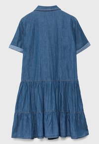 Jeansjurk met korte opgerolde mouwen, kraag en gelaagde rok. Heeft een medium blauwe tint en zachte, gestructureerde stof.