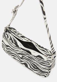 Sac à main à imprimé zèbre fabriqué à partir d'un tissu durable, avec une forme rectangulaire, une fermeture éclair et une bandoulière structurée au design assorti.